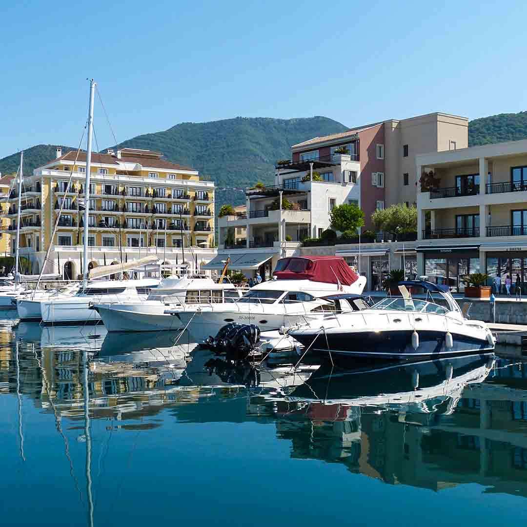 Porto Montenegro Marina with yachts and boats in front of Al Posto Giusto restaurant and Regent Hotel. Berths available for different positions.